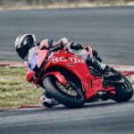 Honda CBR600RR 2027 in piega su un circuito, livrea Ignition Red Tricolour HRC