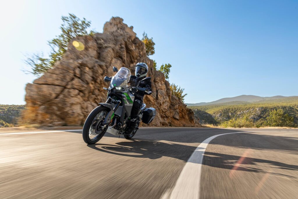 Kawasaki KLE650 2027 in curva su una strada asfaltata di montagna