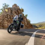Kawasaki KLE650 2027 in curva su una strada asfaltata di montagna
