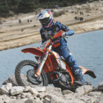 Manuel Lettenbichler in sella alla KTM 300 EXC sulle rocce in riva all'acqua durante la Hixpania Hard Enduro 2026